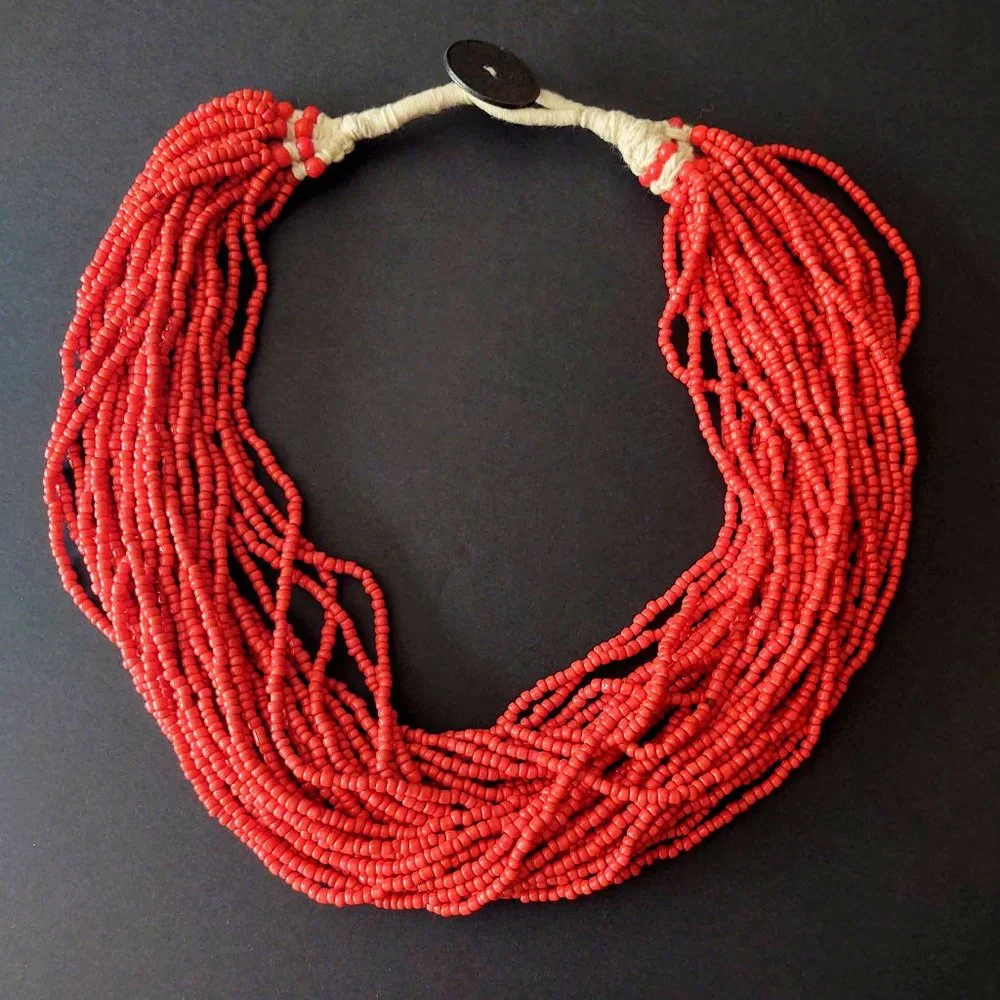 Layered orange beaded necklace with old coin toggle closure